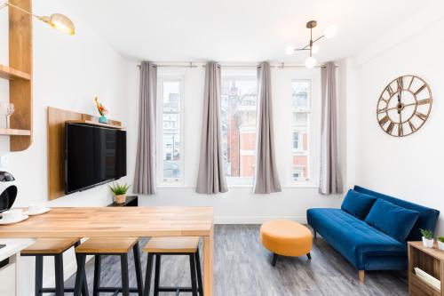 a living room with a blue couch and a table at Indigo Apartment in Birmingham