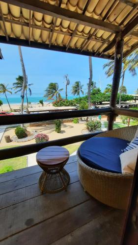弗烈歇德斯的住宿－Pousada do Paiva，一个带一张床和一张桌子的门廊,享有海滩美景
