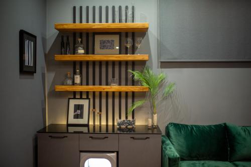 a living room with a green couch and a book shelf at Luxury Cottage in Tsaghkadzor by Downtown Inn in Tsaghkadzor