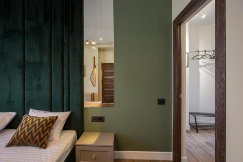 a bedroom with a bed with a green curtain and a mirror at Luxury Cottage in Tsaghkadzor by Downtown Inn in Tsaghkadzor