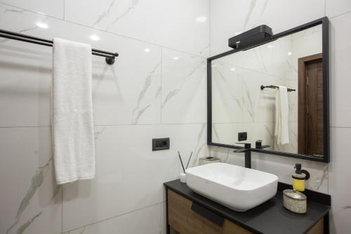 a white bathroom with a sink and a mirror at Luxury Cottage in Tsaghkadzor by Downtown Inn in Tsaghkadzor
