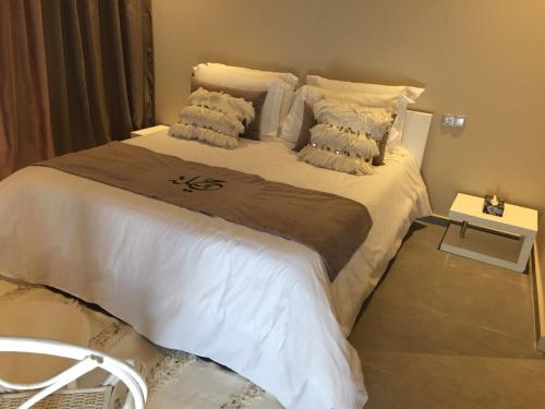a bedroom with a large bed with white sheets and pillows at Villa Jamila -Villa de luxe a Marrakech in Marrakesh