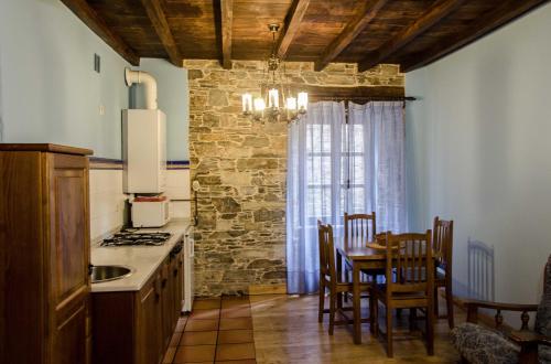cocina con mesa, sillas y ventana en Casas Rurales Taramundi Verde en Taramundi