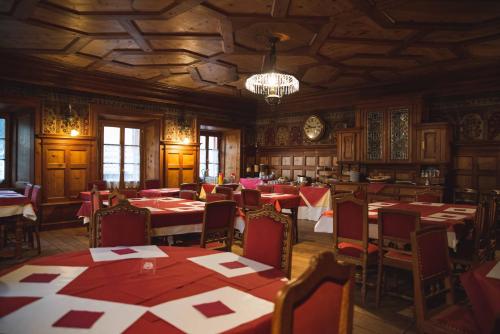 a dining room with tables and chairs and a chandelier at Hotel La Villa della Regina in Gressoney-la-Trinité