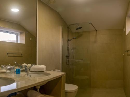 a bathroom with a shower and a sink and a toilet at HI Serra da Estrela - Pousada de Juventude in Penhas da Saúde