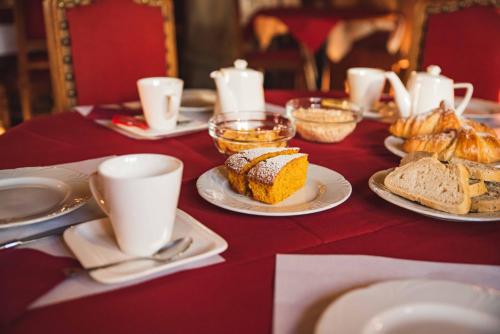 a table topped with plates of bread and cups of coffee at Hotel La Villa della Regina in Gressoney-la-Trinité