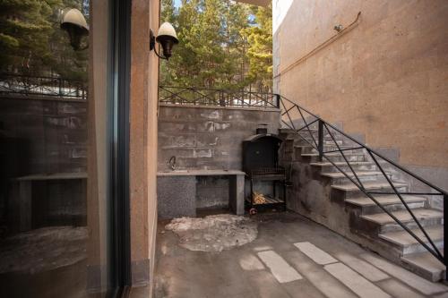 an outdoor patio with a stove and stairs in a building at Luxury Cottage in Tsaghkadzor by Downtown Inn in Tsaghkadzor