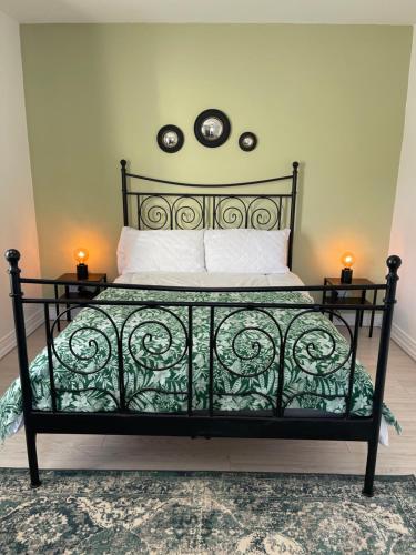 a bedroom with a black bed with two lights on the wall at No2 at Rosebank Apartments in Moville