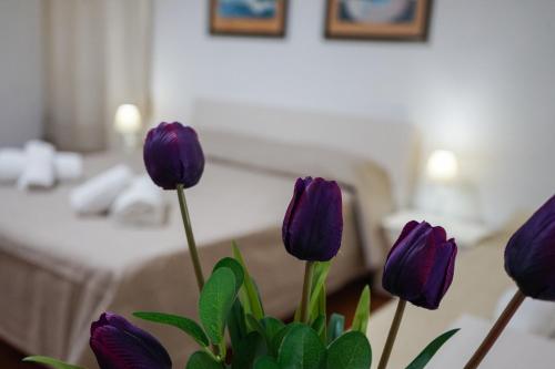 a vase of purple flowers in a hotel room at Ohana by Casimiro in Trapani