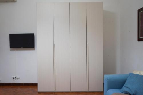 a living room with white cabinets and a blue couch at Ohana by Casimiro in Trapani