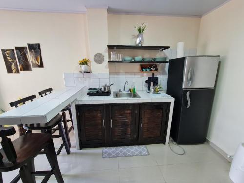 a kitchen with a sink and a refrigerator at Apartamentos Ave del Paraíso in Alajuela City