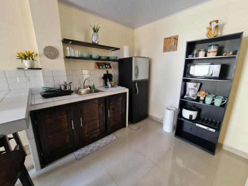 a kitchen with a sink and a refrigerator at Apartamentos Ave del Paraíso in Alajuela City