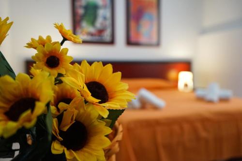 a vase filled with yellow sunflowers in a room at Ohana by Casimiro in Trapani