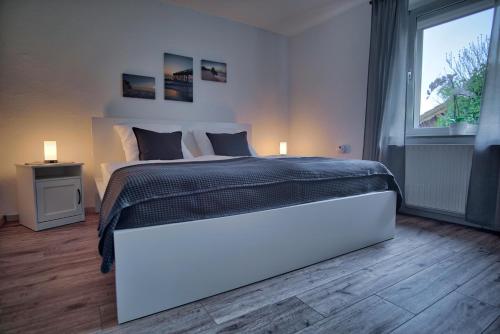 a bedroom with a large white bed and a window at Maisonette privater Zugang Waschmaschine Parkplatz in Hagen