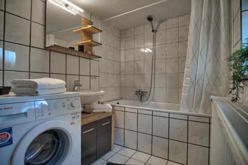 ein Badezimmer mit einer Waschmaschine und einem Waschbecken in der Unterkunft Maisonette privater Zugang Waschmaschine Parkplatz in Hagen