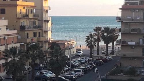 a city street with cars parked next to the ocean at Casa Valente in Ladispoli
