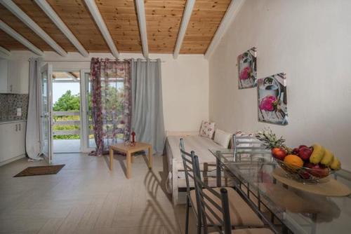 cocina y sala de estar con mesa y sofá en Efi Apartments en Agios Gordios