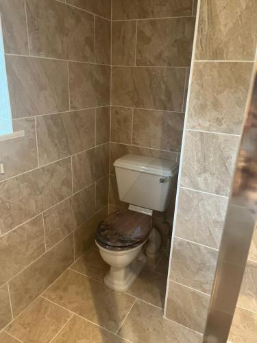 a bathroom with a toilet with a wooden seat at Jasmine House in Newquay