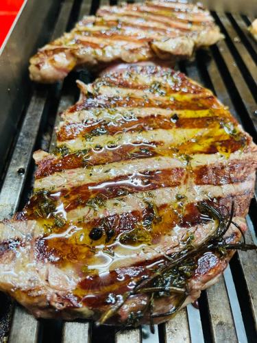 two pieces of meat sitting on a grill at Alpenpension Gasthof in Ratten