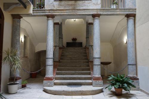 a staircase in a building with pillars and potted plants at Ohana by Casimiro in Trapani