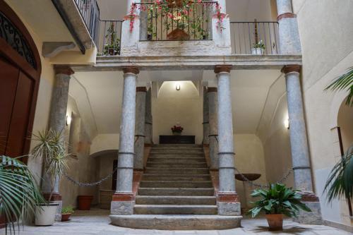 a staircase in a building with potted plants at Ohana by Casimiro in Trapani