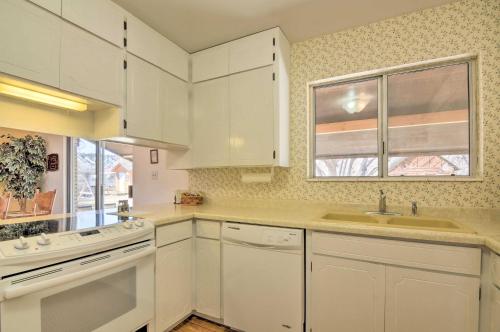 a kitchen with white cabinets and a sink and a window at Bryce Canyon Area House with Mountain Views! in Tropic