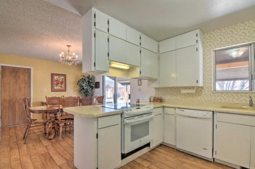 a kitchen with white cabinets and a dining room at Bryce Canyon Area House with Mountain Views! in Tropic