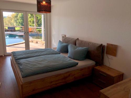 - un lit avec des oreillers bleus dans l'établissement Ferienwohnung Bodanrück, à Meßkirch