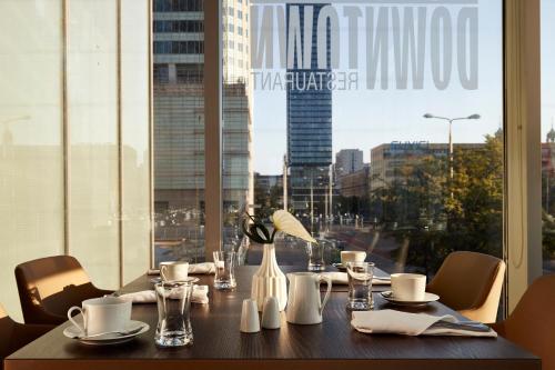 a table with a view of a city from a window at InterContinental Warszawa by IHG in Warsaw