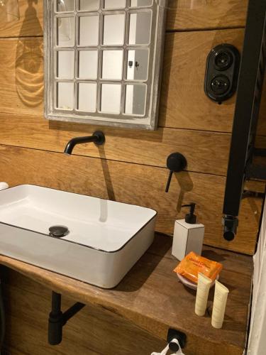a bathroom with a white sink on a wooden counter at Apartament Komorowskiego in Słupsk