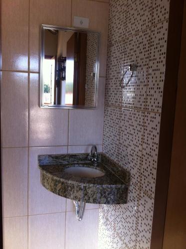 a bathroom with a marble sink and a mirror at Pousada Vista Alegre in Guaratinguetá