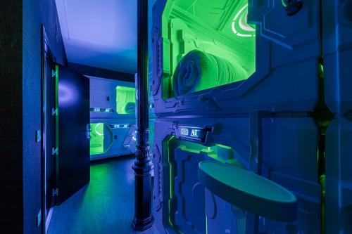 um quarto azul e verde com um lavatório e um espelho em Art Seven Hostel Capsules em Madrid
