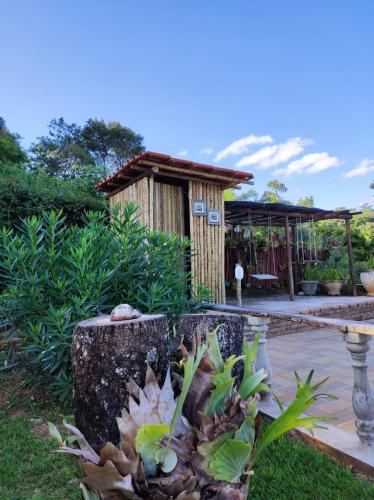 a garden with a tree stump and a house at Quinta da Bela Vista in Caeté