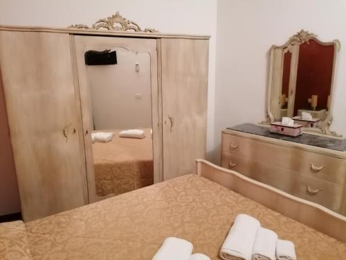 a bathroom with a mirror and a dresser with towels at Casa Vacanza Za' Giuvannina in Sciacca