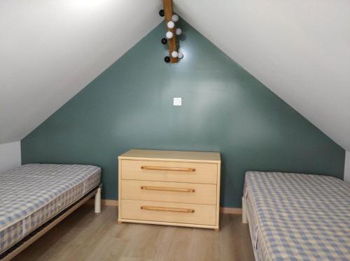 2 camas y un vestidor en el dormitorio del ático en Les petits gites, en Ernée