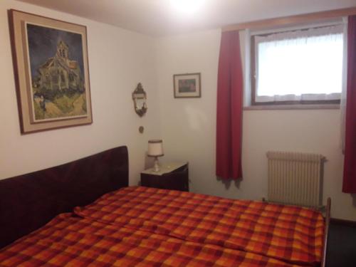 een slaapkamer met een bed en een raam met rode gordijnen bij RESIDENCE KORMORANO MALCESINE in Malcesine