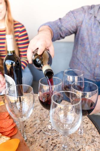 a man pouring wine into wine glasses on a table at The Bank Hotel in Lake Arthur