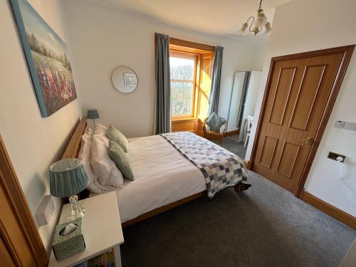a bedroom with a large bed and a window at Morven Guest House Carnoustie in Carnoustie