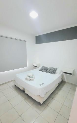 1 dormitorio blanco con 1 cama en una habitación en Zafiro III en Santa Fe