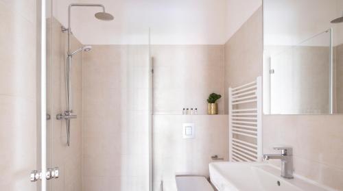 uma casa de banho branca com um chuveiro e um lavatório. em Arbio I Design Studio near Charlottenburg Palace em Berlim