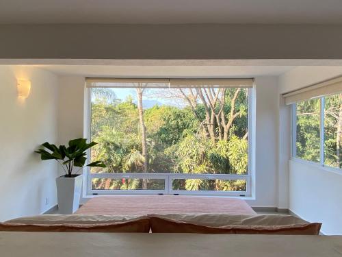 a bedroom with a large window with a bed at Hotel Marjaba in Cuernavaca