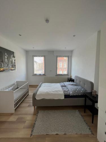 sypialnia z łóżkiem i kanapą oraz 2 oknami w obiekcie Zentrale Ferienwohnung w mieście Bad Lippspringe