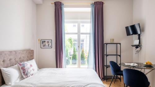 um quarto com uma cama, uma secretária e uma janela em Arbio I Design Studio near Charlottenburg Palace em Berlim