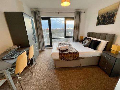 Un dormitorio con una cama y un escritorio con una computadora. en Empire Serviced Apartments, en Leicester