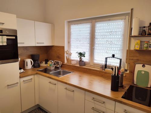 a kitchen with white cabinets and a sink and a window at Ferienwohnung Susanna in Friedrichshafen