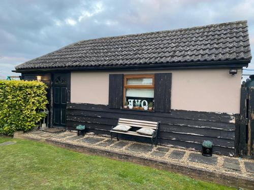 a house with a bench in front of a window at The Glen Guest House 1-bedroom guest house with free parking in Fyfield