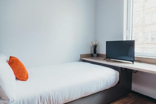a bedroom with a bed and a desk with a computer at Quarter by the Warren Collection in Belfast