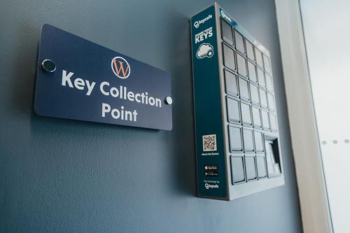a key collection point sign on a wall at Quarter by the Warren Collection in Belfast