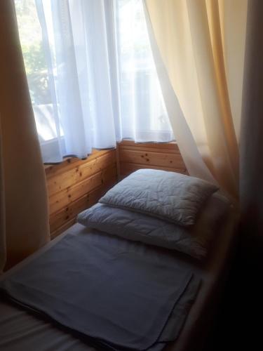 łóżko w pokoju z oknem w obiekcie Elżbieta w Pobierowie