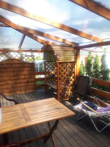 a wooden deck with a wooden table and chairs on it at Elżbieta in Pobierowo